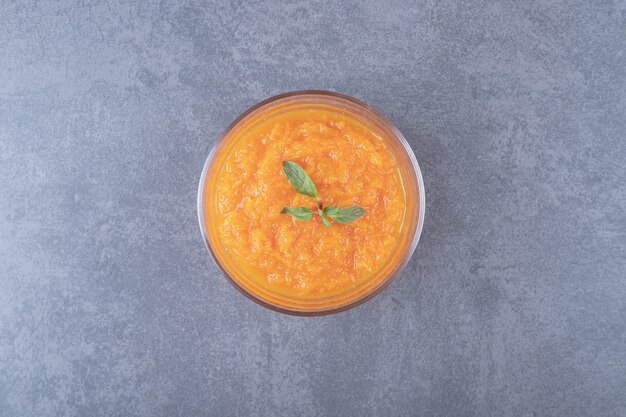 A bowl of lentil soup, on the marble surface.