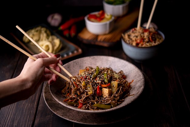 Bowl of noodles with vegetables and other asian food