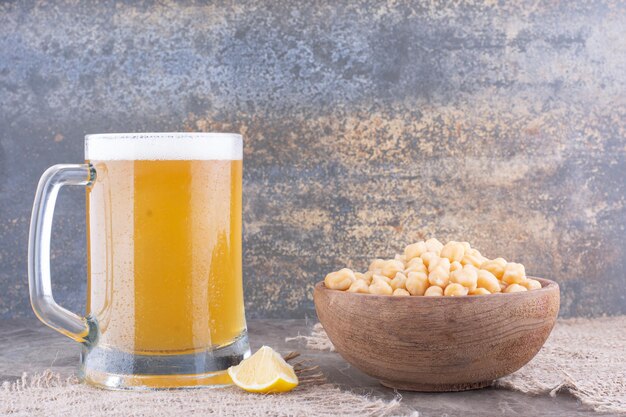 Bowl of peas and glass of beer on marble table. High quality photo