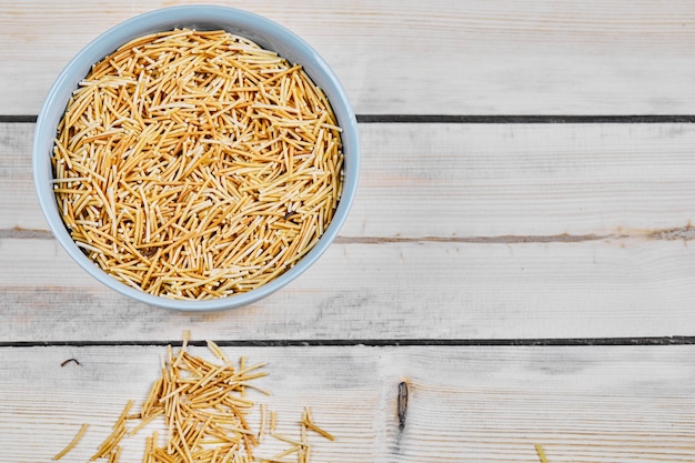 Free Photo a bowl of raw pasta on wooden table