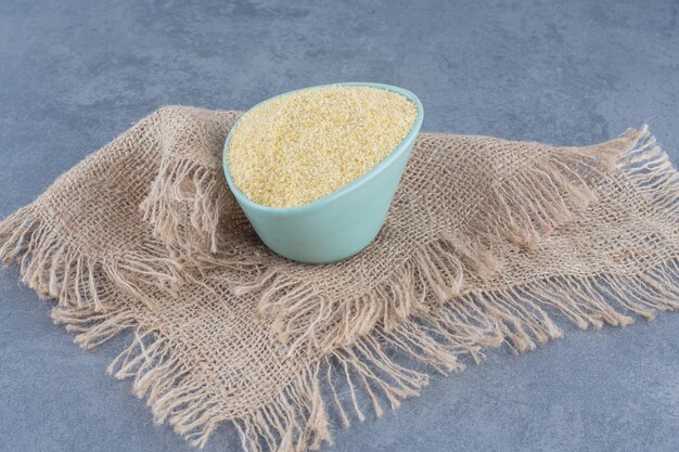 A bowl of rice on the towel, on the marble background. 