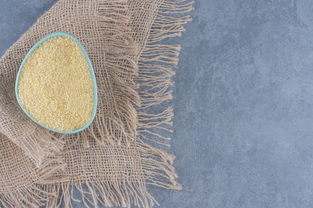 A bowl of rice on the towel, on the marble background. 