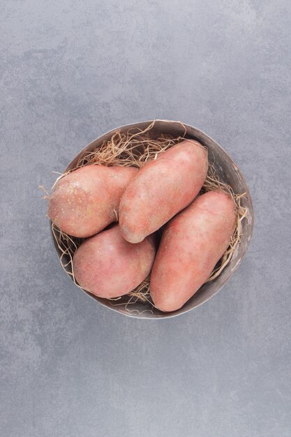 A bowl of ripe potato on the marble surface