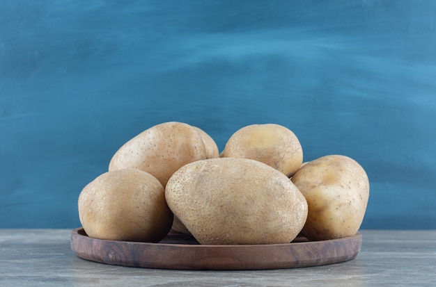 A bowl of ripe potato on the marble table. 