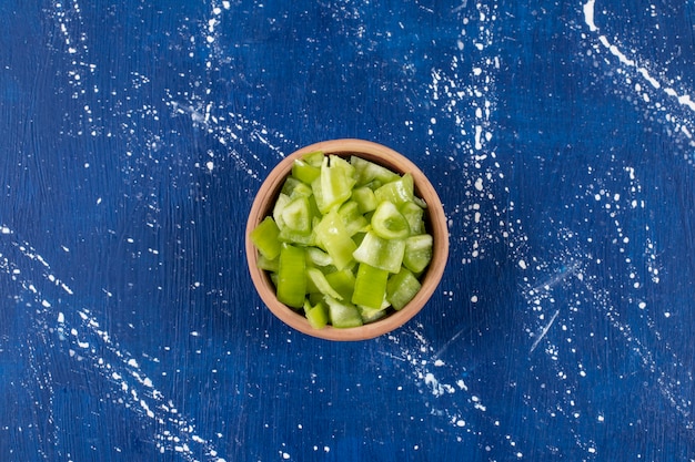 Free Photo bowl of sliced green bell peppers on marble surface