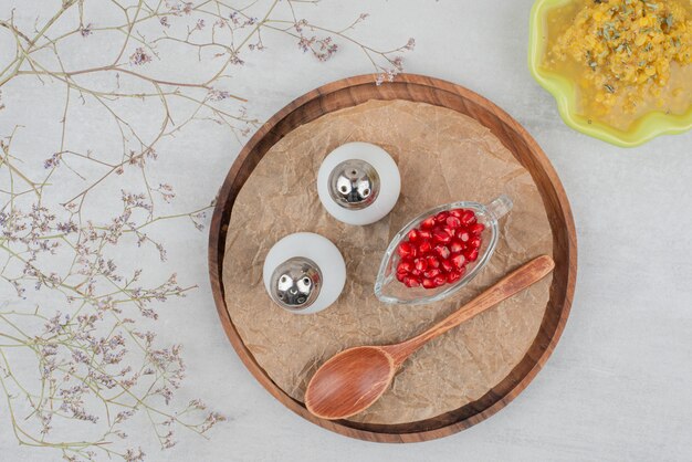 Bowl of soup, salt and pomegranate seeds on white.