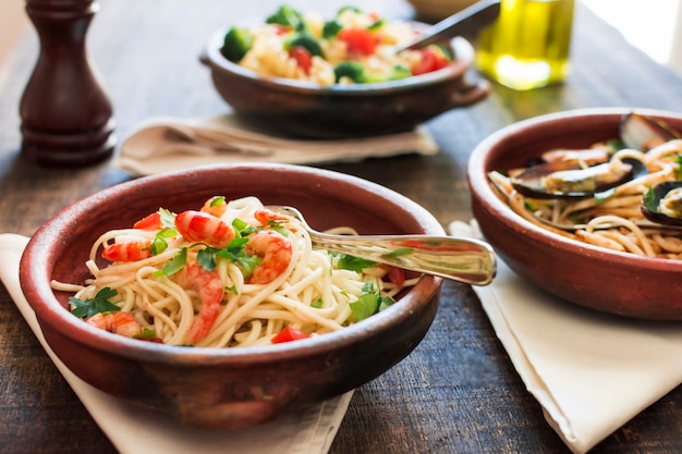 Bowl of spaghetti with shrimps on wooden table