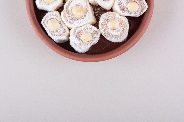 Bowl of sweet lokum dessert with nuts on white background. High quality photo