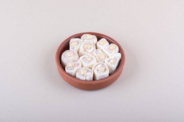 Bowl of sweet lokum dessert with nuts on white background. High quality photo