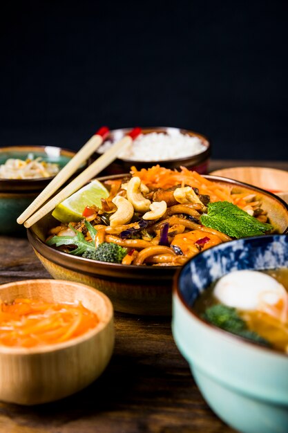 Bowl of thai udon noodles with nuts; broccoli; lemon and mint toppings