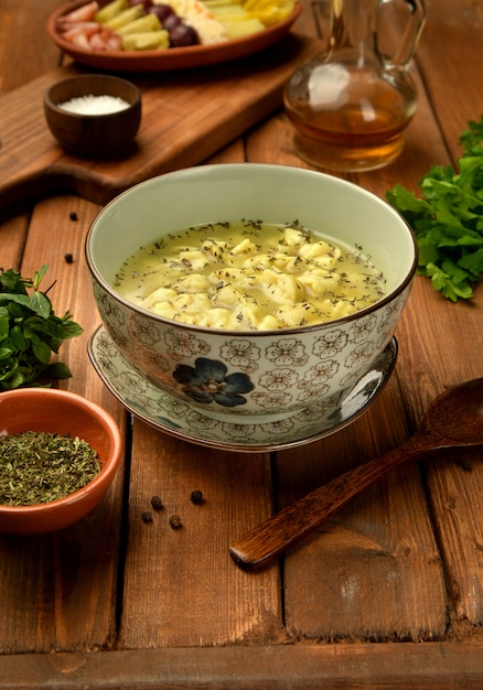 Free photo bowl of traditional azerbaijani dushbara dumpling soup served with vinegar and dried mint