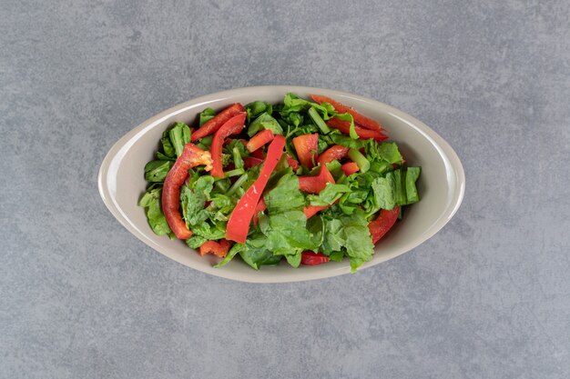 Bowl of vegetable salad on marble background. High quality photo