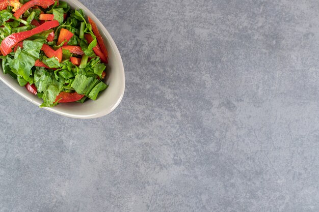 Bowl of vegetable salad on marble background. High quality photo