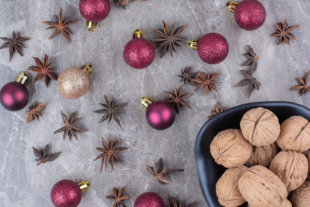 Bowl of walnuts with cloves and Christmas balls. 