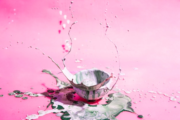 Free photo bowl with mixed paint and pink background