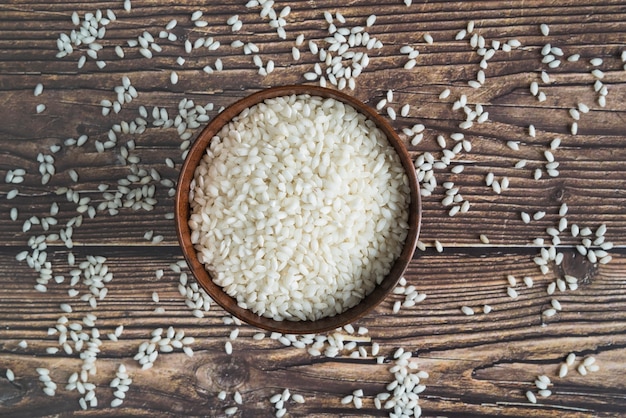 Bowl with rice on desk with scattered grains