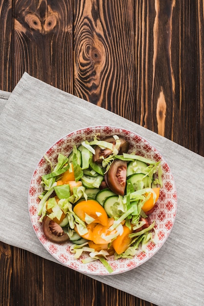 Free photo bowl with salad standing on napkin