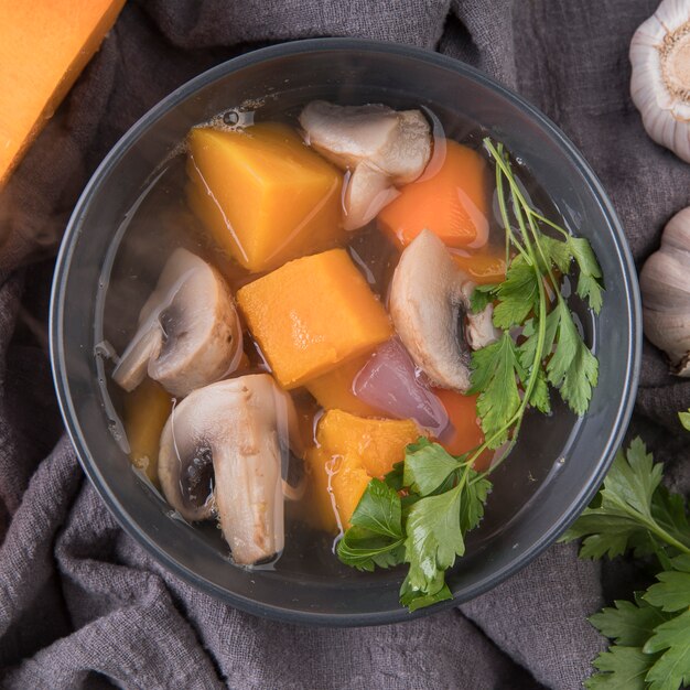 Bowl with soup ingredients and broth close-up