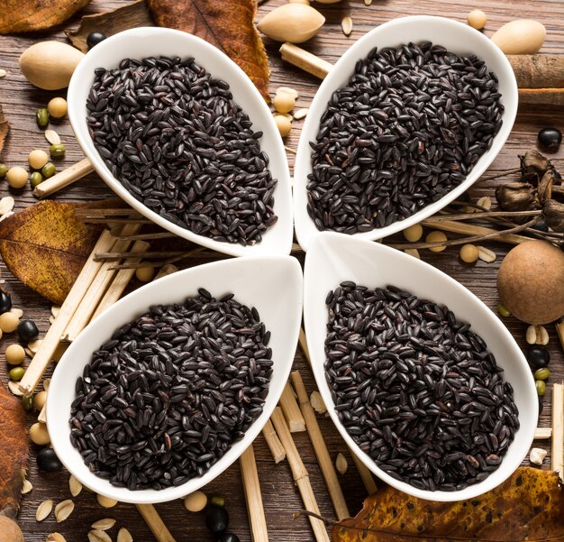 Bowls of black rice on wooden table