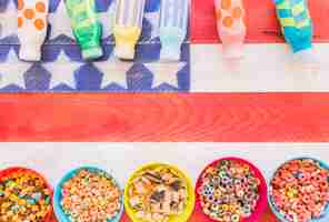 Free photo bowls of cereals with milk bottles on table