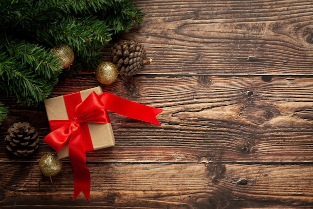 Box of present with red ribbon bow on wooden background