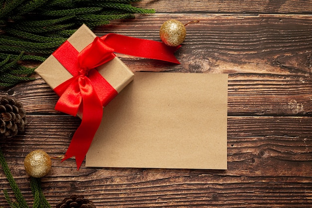 Box of present with red ribbon bow on wooden background