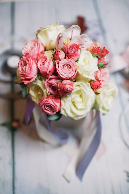 Box with white and orange bouquet stands on florist's working ta