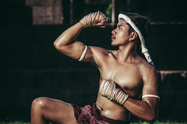 Free Photo a boxer tied a rope in his hand and performed a fight, the martial arts of muay thai.