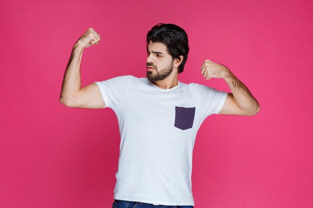 Boxing man showing his fists and makes point to his strength. 