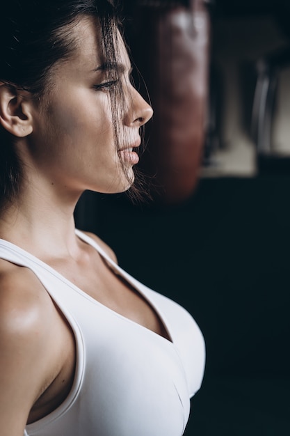 Free Photo boxing woman posing with punching bag. strong and independent woman concept