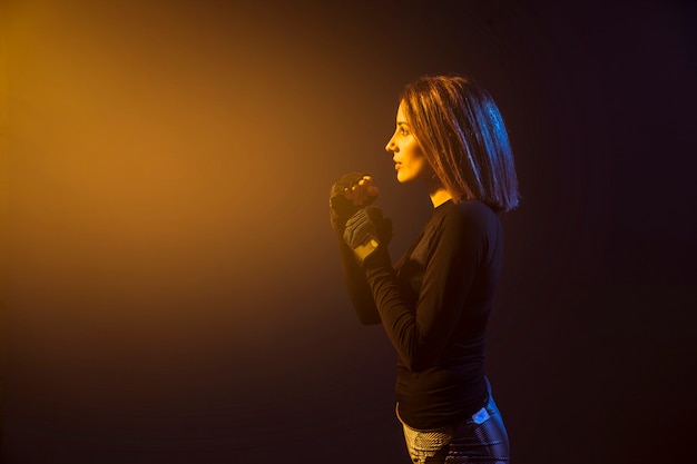 Boxing woman in yellow light