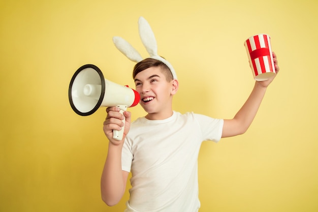 Free Photo boy as an easter bunny on yellow wall