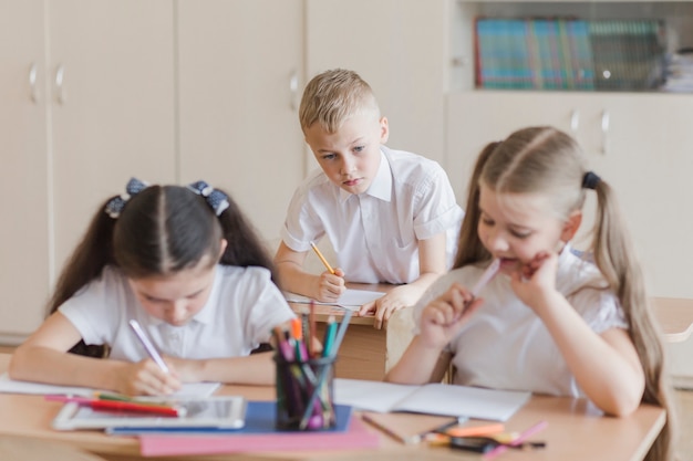 Boy copying answers of classmates