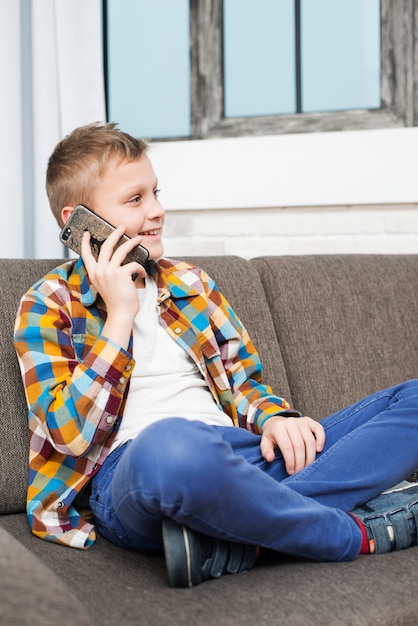 Boy on couch making phone call