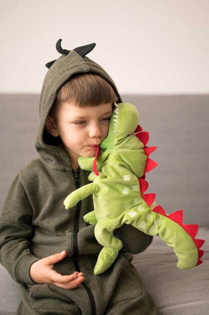 Boy in dinosaur costume playing