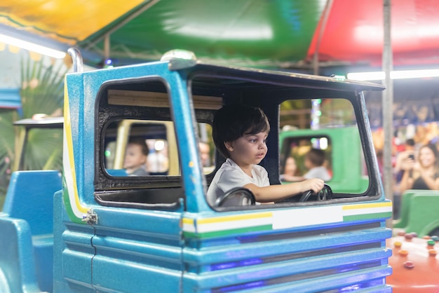 Free Photo boy driving toy truck at amusement park