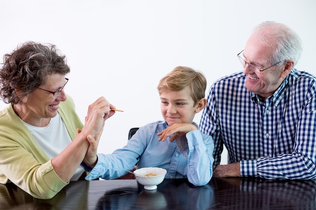 Free photo boy eating kid female grandmother