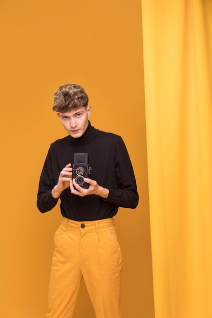 Boy filming with a camcorder in a yellow scene