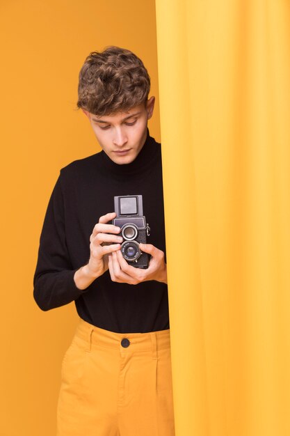 Boy filming with a camcorder in a yellow scene