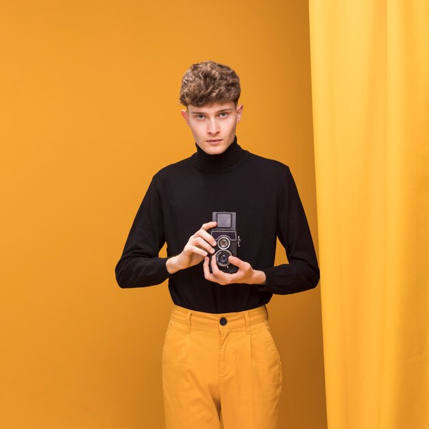 Boy filming with a camcorder in a yellow scene