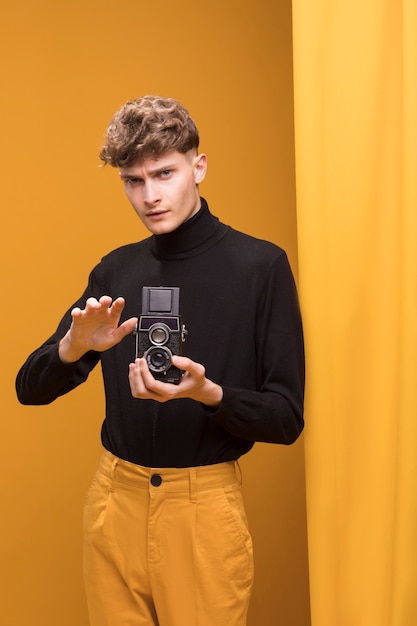 Boy filming with a camcorder in a yellow scene