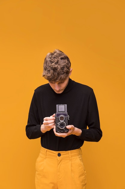 Free photo boy filming with a camcorder in a yellow scene