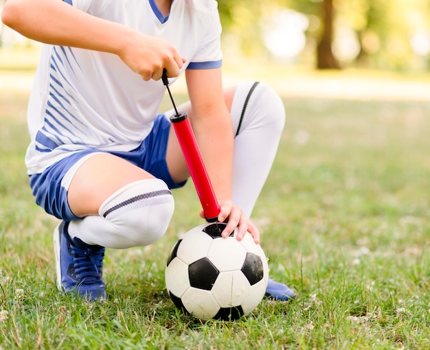 Free photo boy getting ready his football for a new match close-up