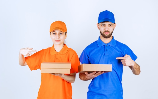 Free photo boy and girl in blue and yellow uniforms holding multiple takeaway packages.