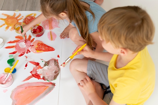 Free photo boy and girl painting together close up