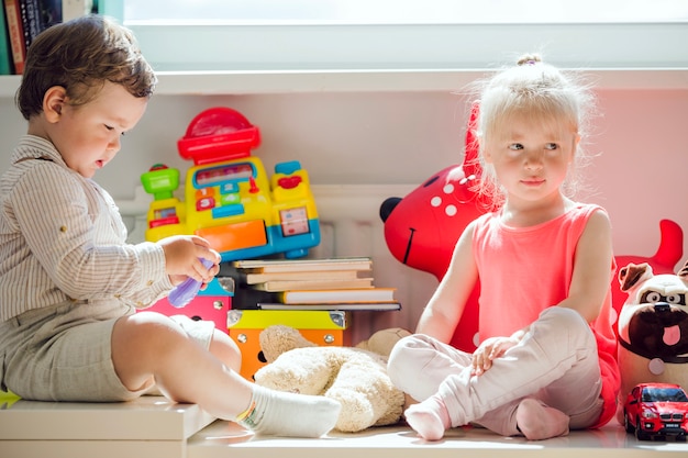 Boy and girl sitting at window posing