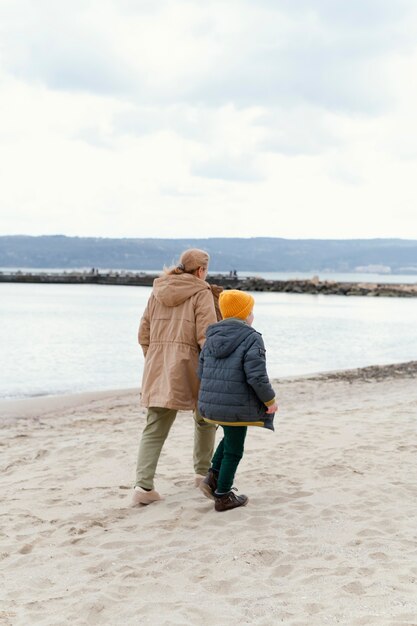 Boy and grandmother at beach full shot