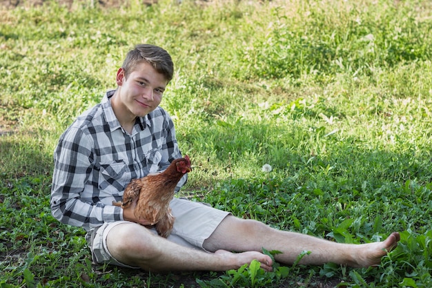 Free Photo boy in grass playing with chicken