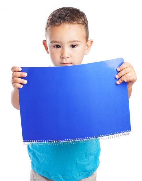 Boy holding a notebook in front of him