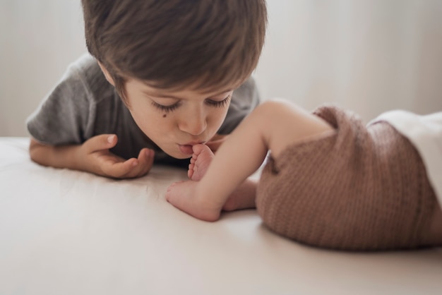 Boy kissing little brother leg